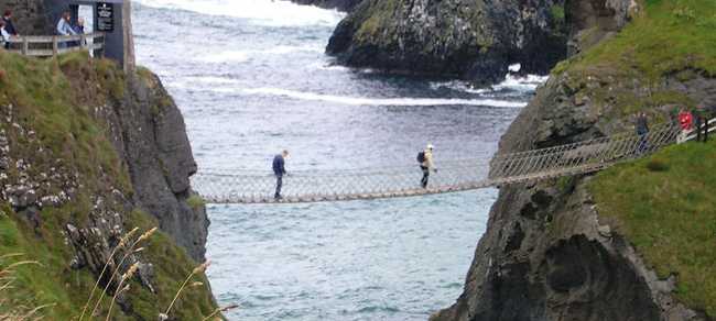 A group of people crossing a rope bridge